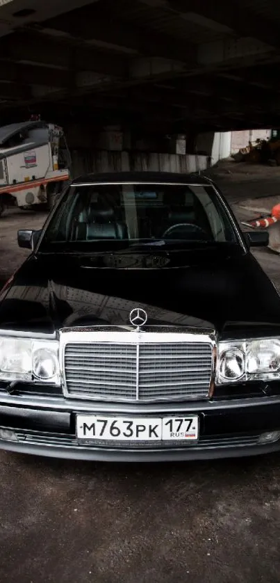 Classic Mercedes parked under a city bridge.