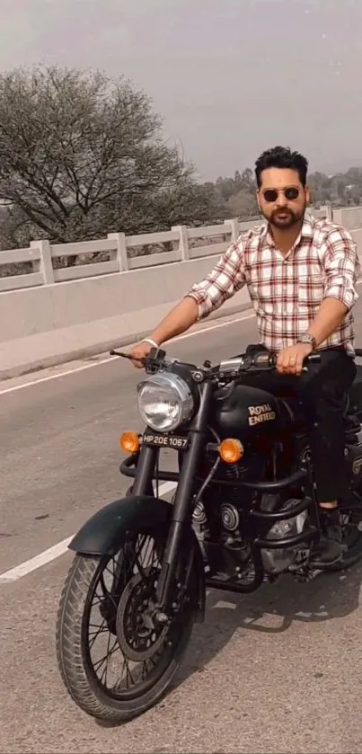 Man riding a classic motorcycle on a scenic road.