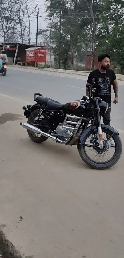 Man standing by a classic motorcycle on a city roadside.