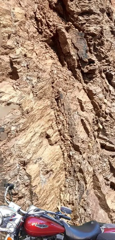 Motorcycle parked in front of rugged rock formation, exuding adventure.