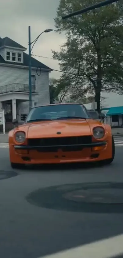 Classic orange car driving on an urban street, perfect for mobile wallpapers.