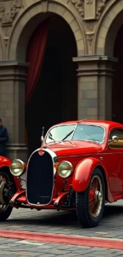 Classic red vintage car in historic town setting.