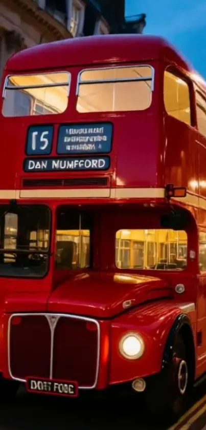 Red double-decker bus at night in London.