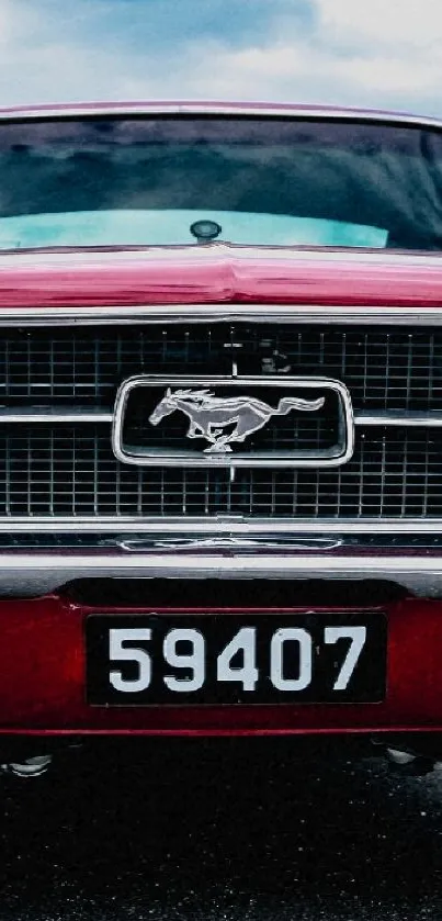 Front view of a classic red Mustang car in a parking lot.