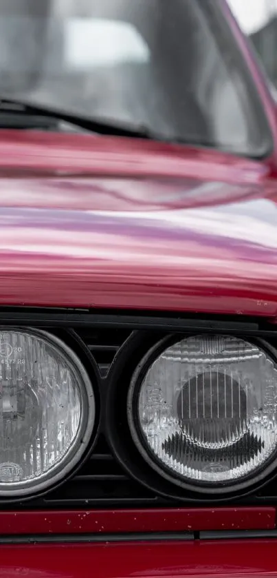 Classic red sports car with stylish headlight design in focus.