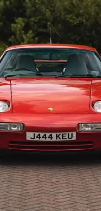 Classic red sports car parked outdoors, view from front.