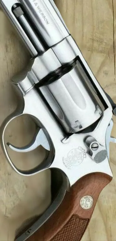 Silver revolver on rustic wooden surface wallpaper.