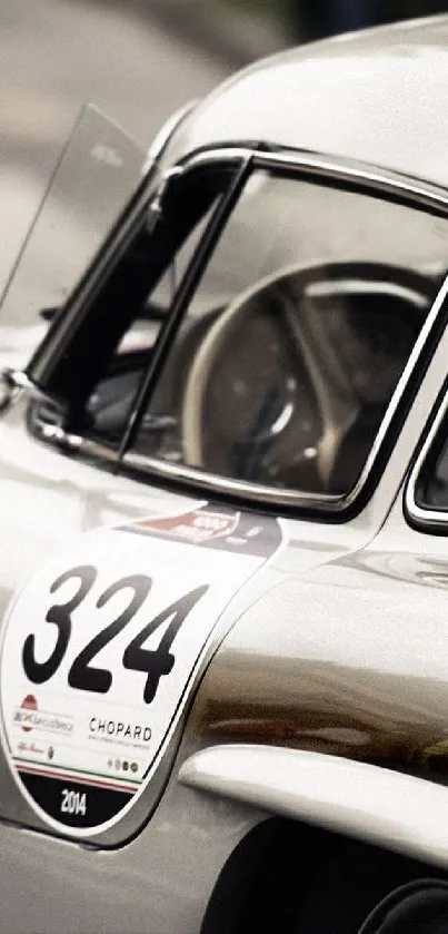 Close-up of a classic silver sports car with racing number 324.