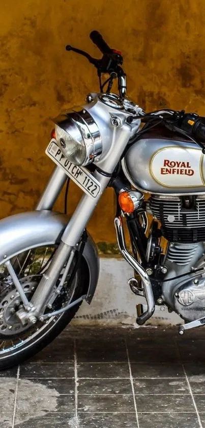 Vintage Royal Enfield motorcycle against a rustic yellow wall.