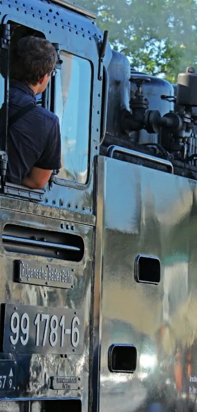 Vintage steam train with engineer looking out.