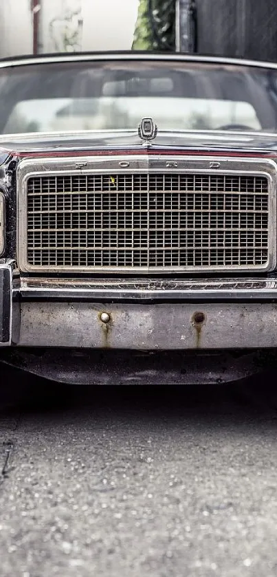 Front view of a vintage Ford car with detailed grille in an alley.