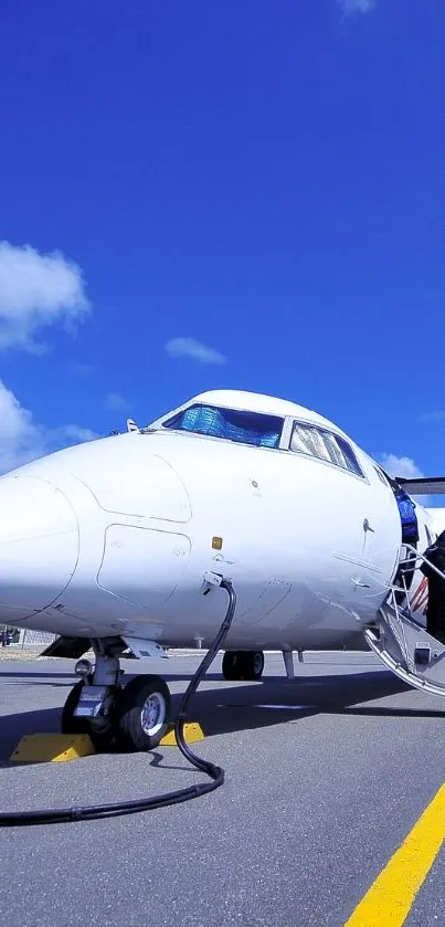 Small aircraft ready for boarding against a bright blue sky on the runway.