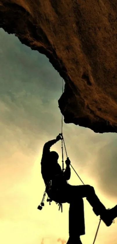 Silhouette of a climber against a golden sunset sky on a mobile wallpaper.