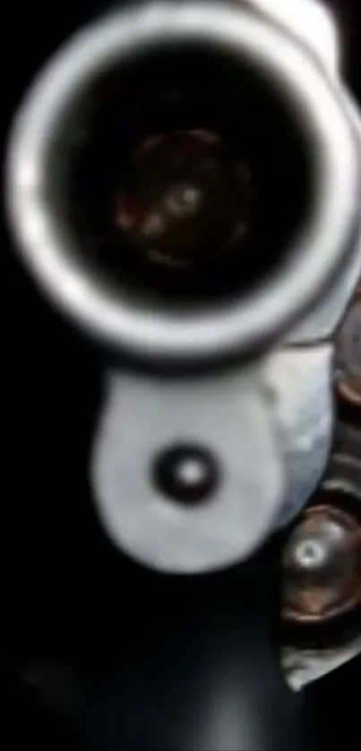 Close-up view of a gun barrel with metallic details in a dark setting.