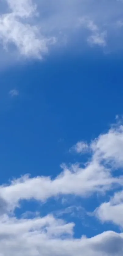 Peaceful blue sky with white clouds wallpaper.