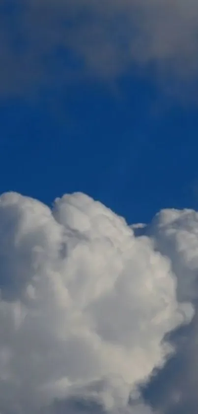 Fluffy white clouds against a clear blue sky on a mobile wallpaper.