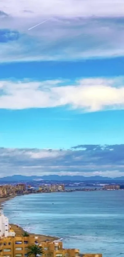 Scenic coastal city skyline with ocean and blue sky.