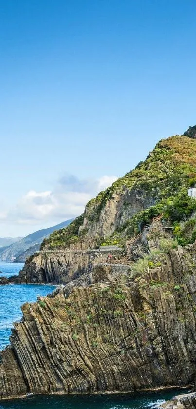 Rugged coastal cliffs with a vibrant blue sky background.