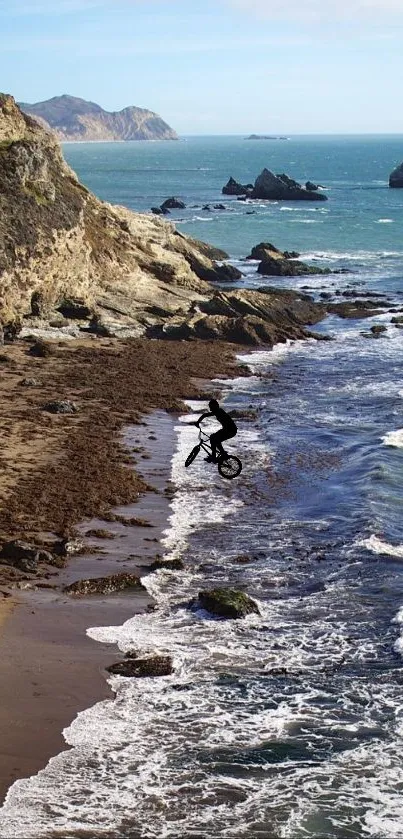 Cyclist riding by the ocean on rocky coastal terrain.