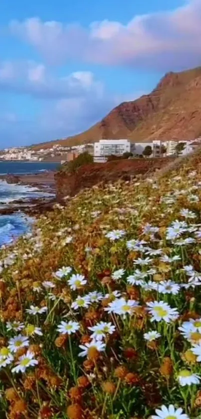 Scenic wallpaper with daisies, ocean, and mountains under a blue sky.