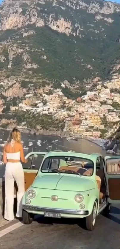 Vintage car on coastal road with mountain view.