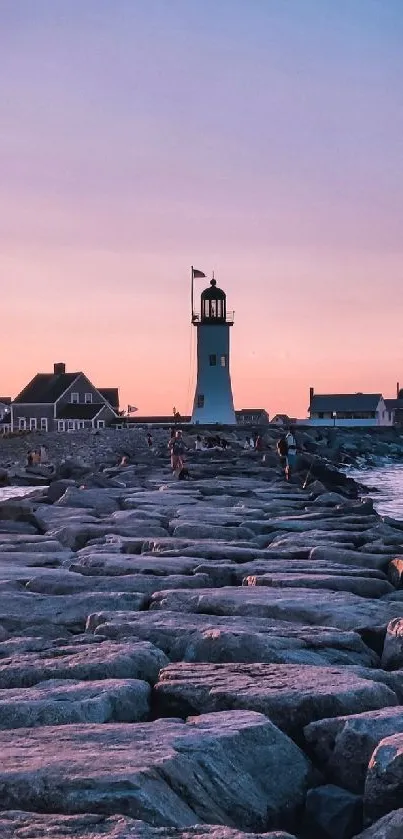 Lighthouse on a rocky pier at sunset with vibrant pink sky.