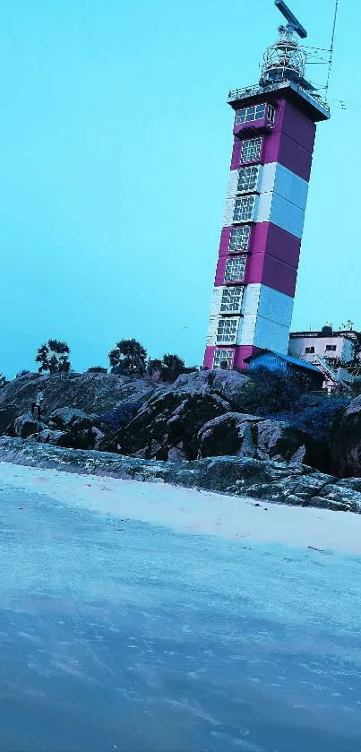 Lighthouse by the beach under a blue sky.