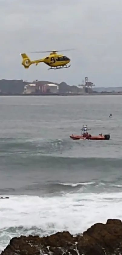 Yellow helicopter hovering above ocean waves near coastline.