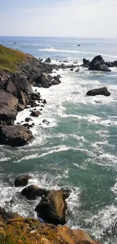 Rugged cliffs and ocean waves under a blue sky.