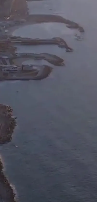 Aerial view of a coastal sunset scene with ocean and shoreline.