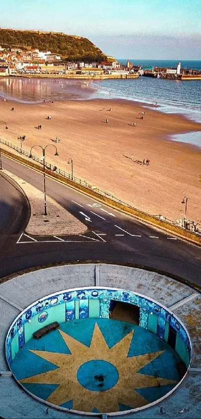 Aerial view of a coastal town with beach and circular structure.