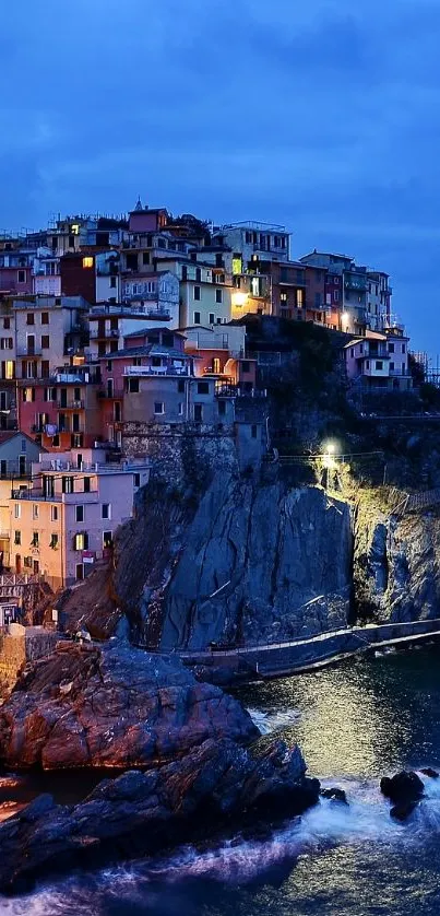 Scenic coastal village at night with vibrant lights and ocean view.