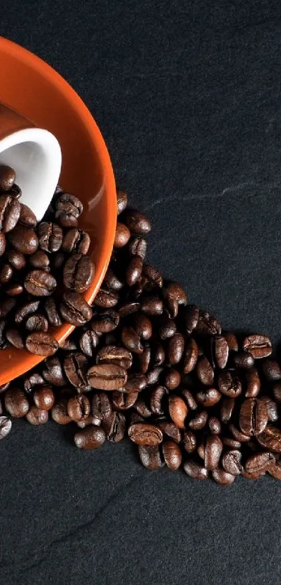 Coffee beans spilling on dark slate background.