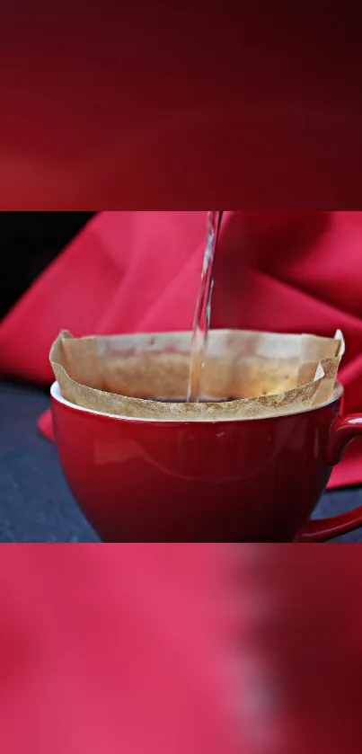 Red mug with coffee pour and soft red background.