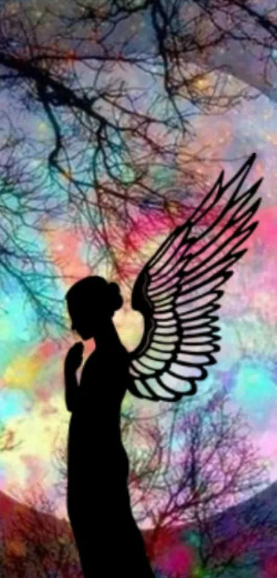 Silhouette of angel with colorful cosmic background and tree branches.