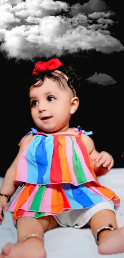 Adorable baby with colorful dress and cloud on black background.