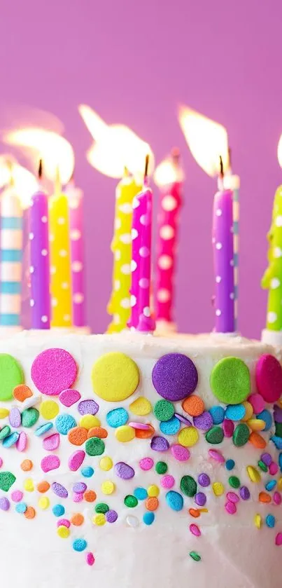 Colorful birthday cake with lit candles on purple background.