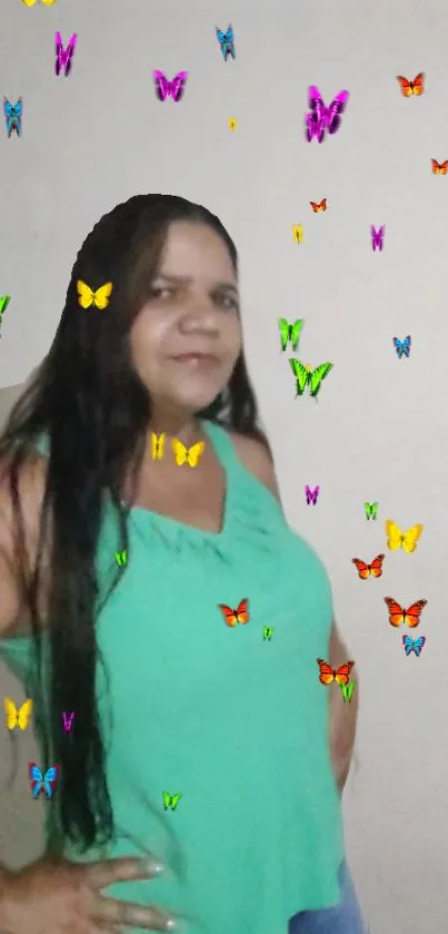 Woman in a green top with colorful butterfly overlay.