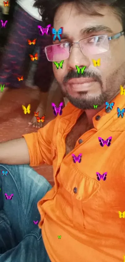 Man wearing an orange shirt with colorful butterfly overlay, vibrant design.