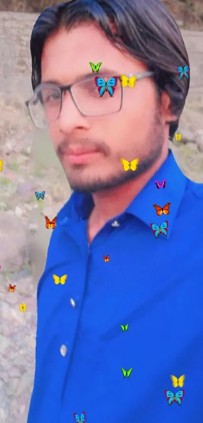 Portrait with vibrant blue shirt and colorful butterfly overlay.