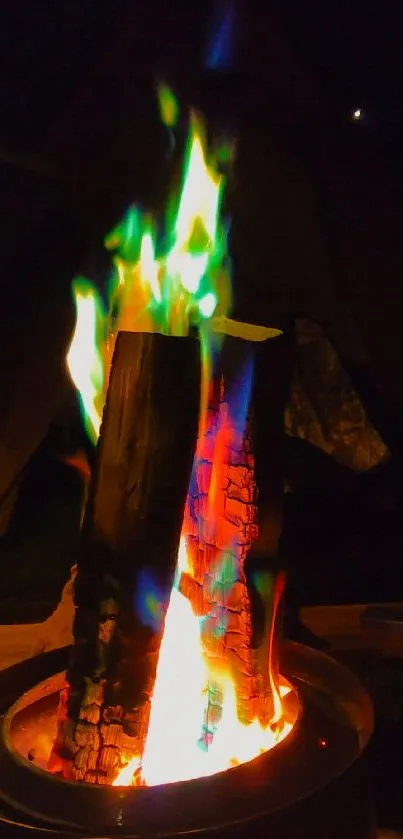 Colorful flames rising from a campfire at night.