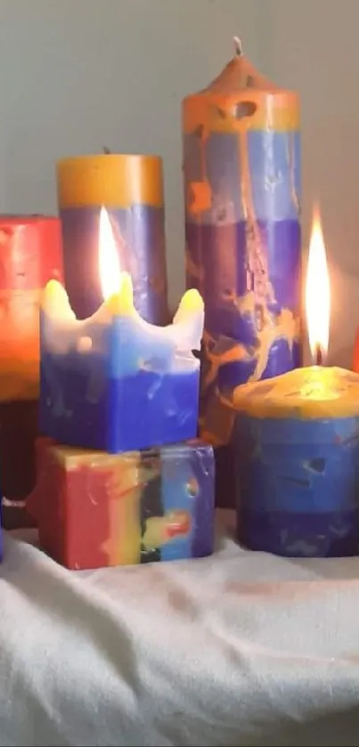 Colorful candles in various shapes on a soft beige cloth.