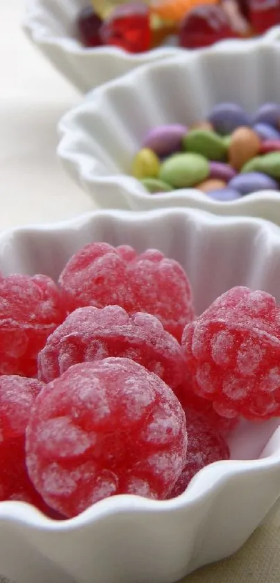 Assorted colorful candies in white dishes for a vibrant phone wallpaper.