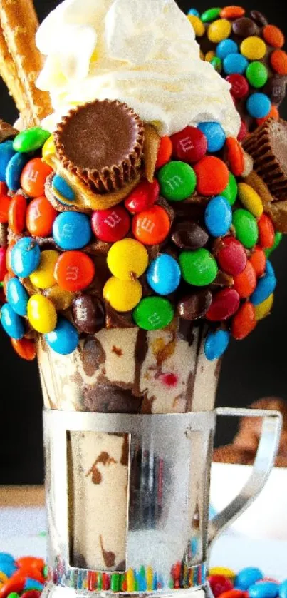 Colorful dessert topped with candy and cream in a tall glass.