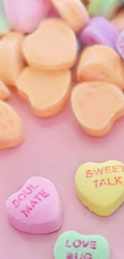 Colorful candy hearts on a pink background.