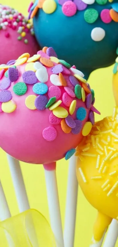 Colorful cake pops with sprinkles on a bright yellow background.