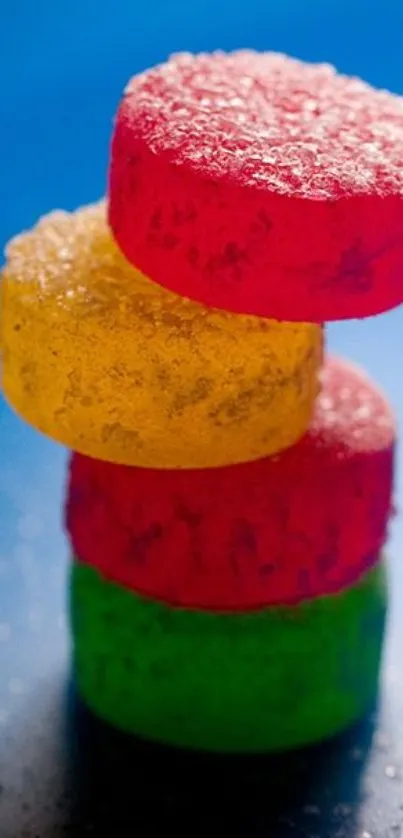 Stack of colorful, sugar-coated candies against a vivid blue background.