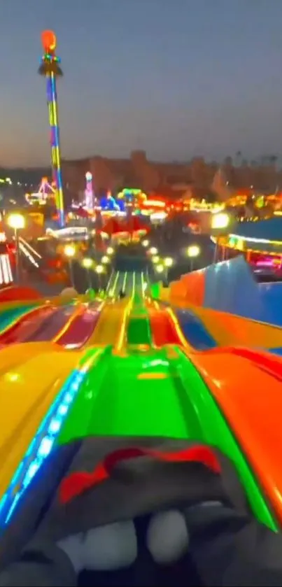 Colorful carnival slide at night with vibrant lights.