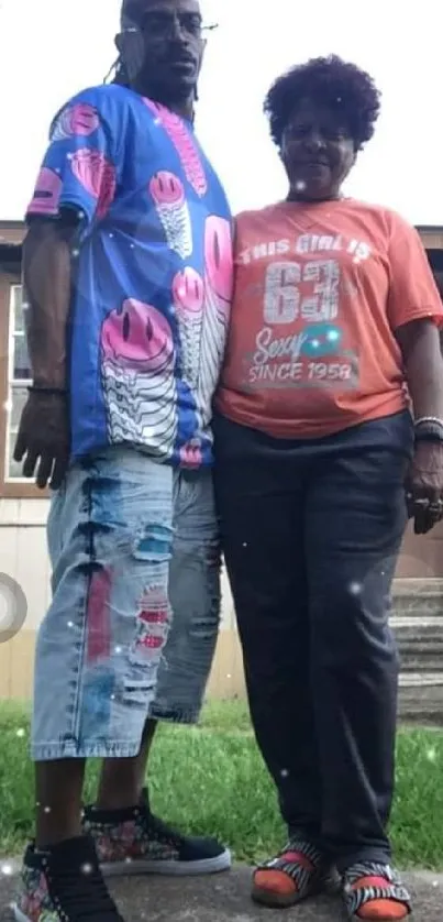 A couple in vibrant clothes posing outdoors.