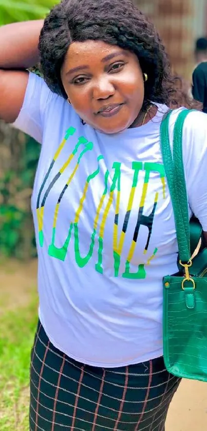 Woman in white t-shirt and plaid skirt with green handbag in a vibrant setting.